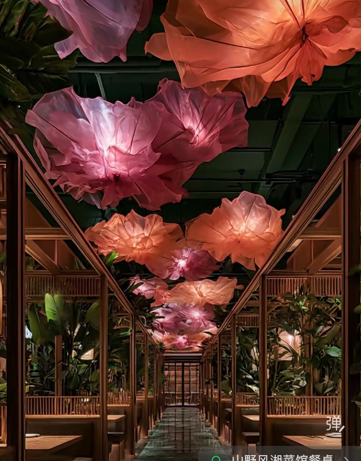 Restaurant walkway with large illuminated flower forms and greenery